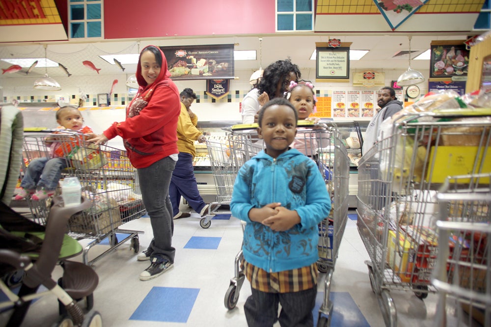 Customers smile while waiting in line at the deli at Cousin's supermarket