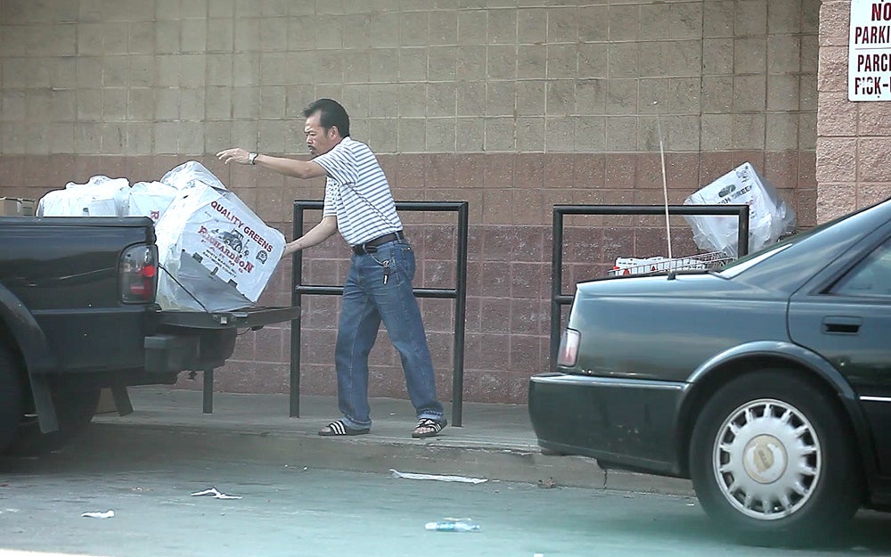 A customer loads boxes of greens into his truck outside the storefront located on 5th and Berks.