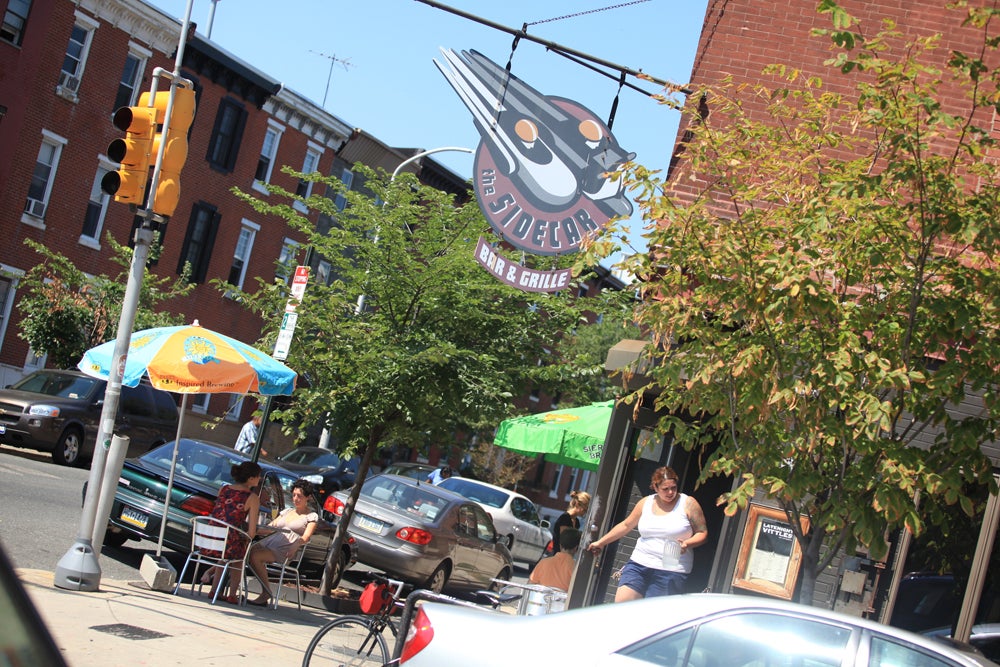 Patrons leave the Sidecar bar located on 22nd and Christian Streets. | Photo: Neal Santos