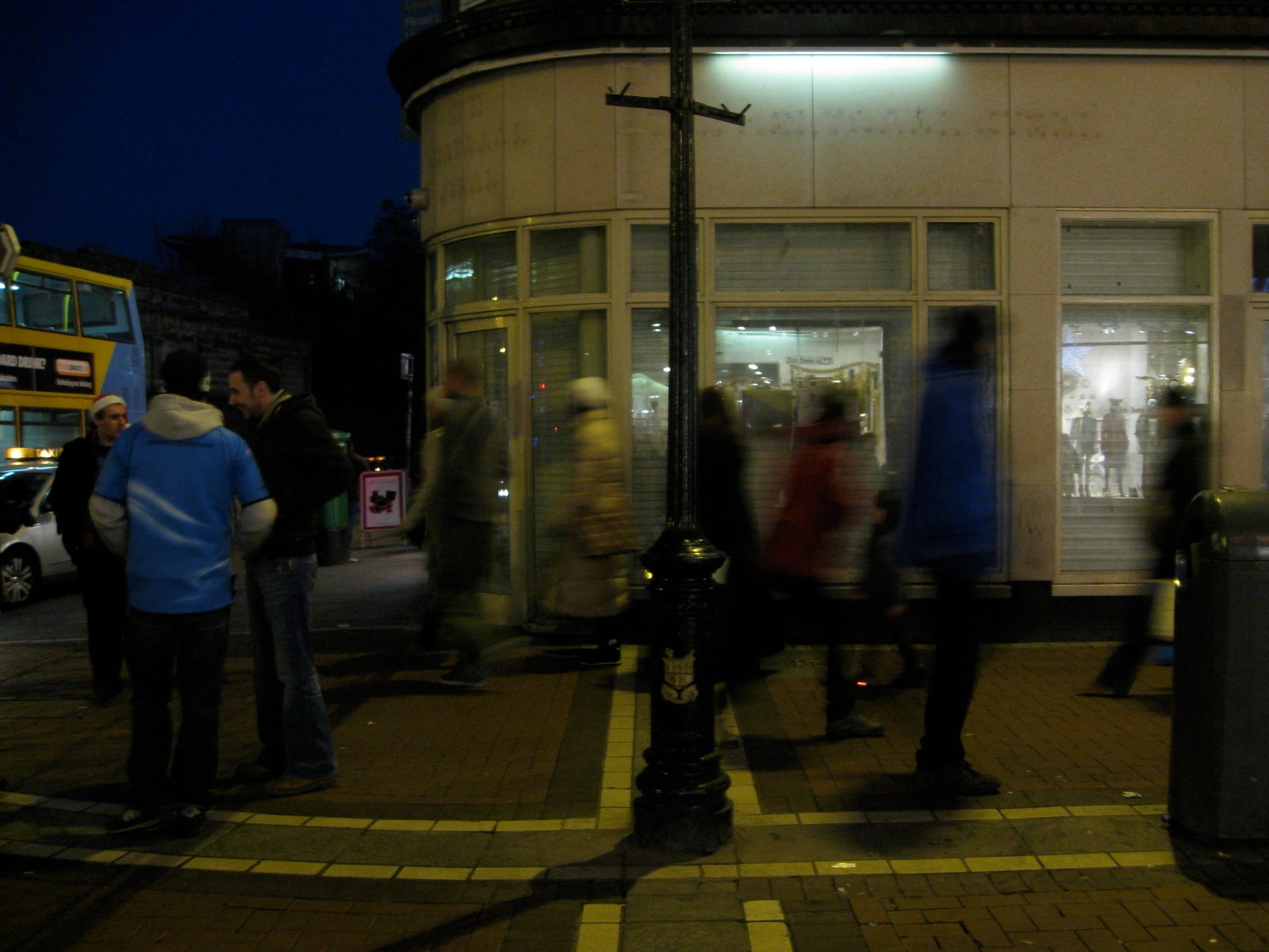 Locals passing a closed storefront while doing their Christmas shopping on Grafton Street