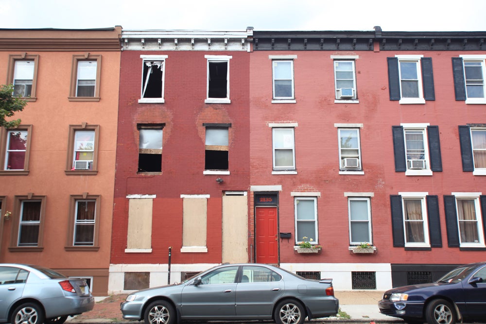 An abandoned shell sits next to redeveloped houses along 21st and Christian streets. | Photo: Neal Santos