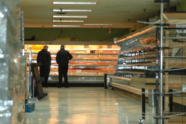 Two men connected to the real estate business perused a nearly packed up Fresh Grocer on Wednesday. (Patrick Cobbs/ NewsWorks