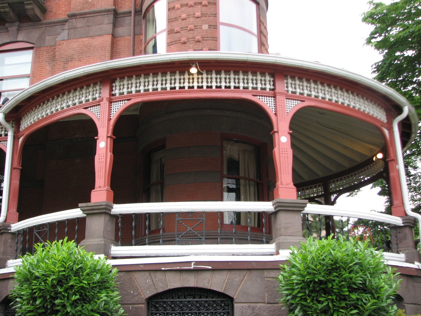 The ornate Victorian porch rolls around the front and side of the house.