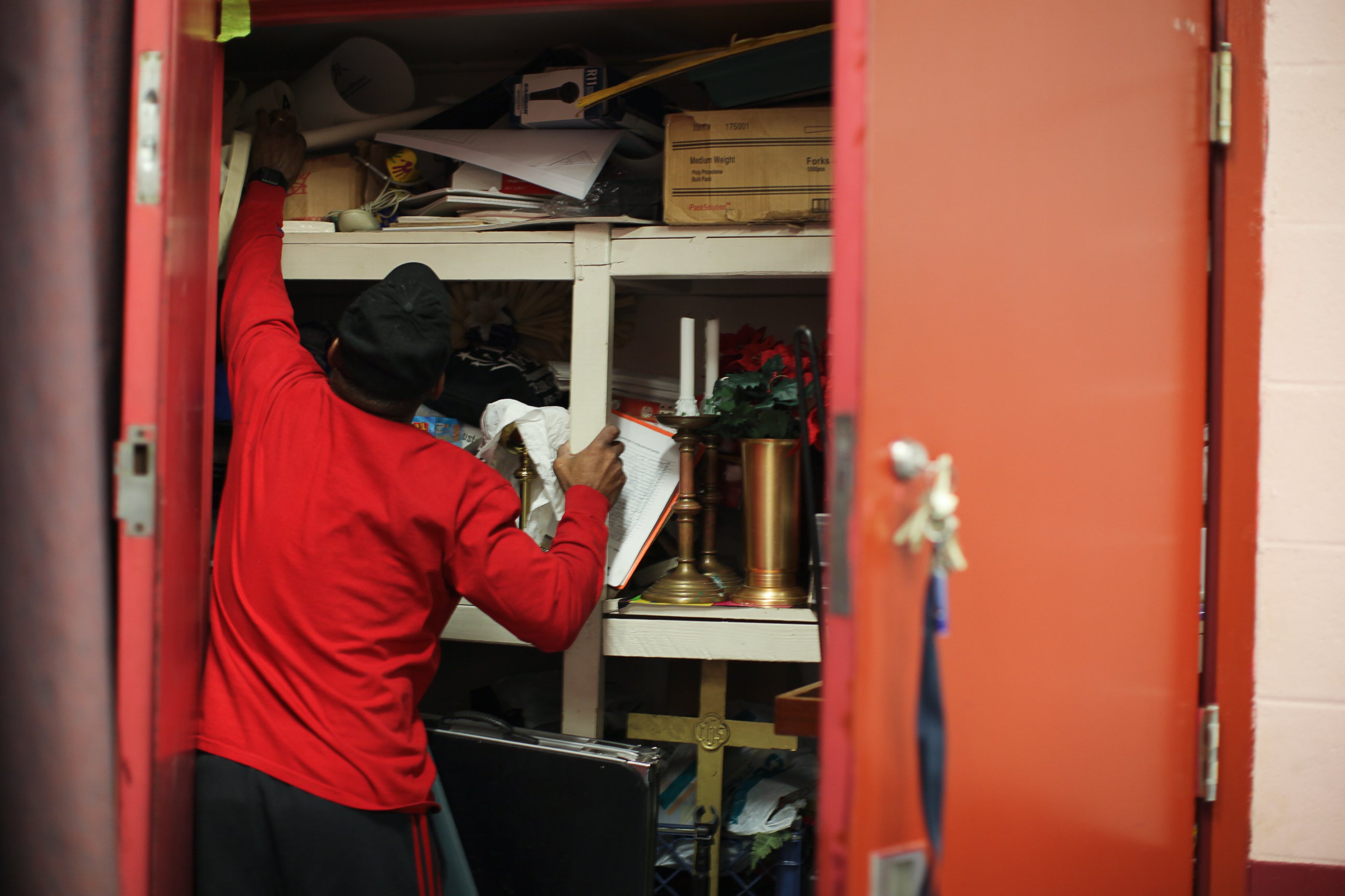 Dana Clark reaches in a storage closet for chess pieces.