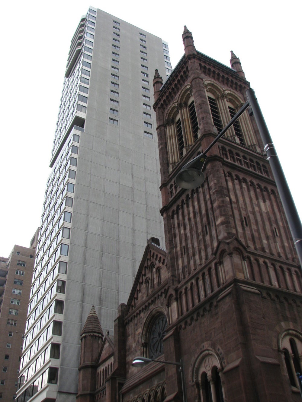 The Holy Trinity tower hold its own against the neighboring condo tower.