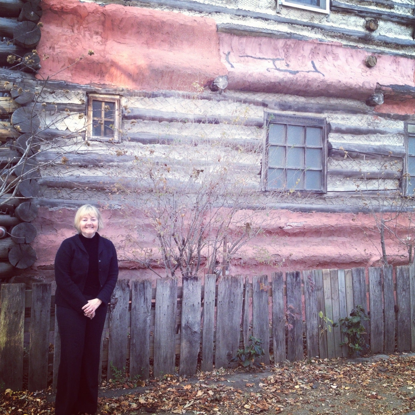 Colleen Davis at the log house artist Jeff Thomas built. 