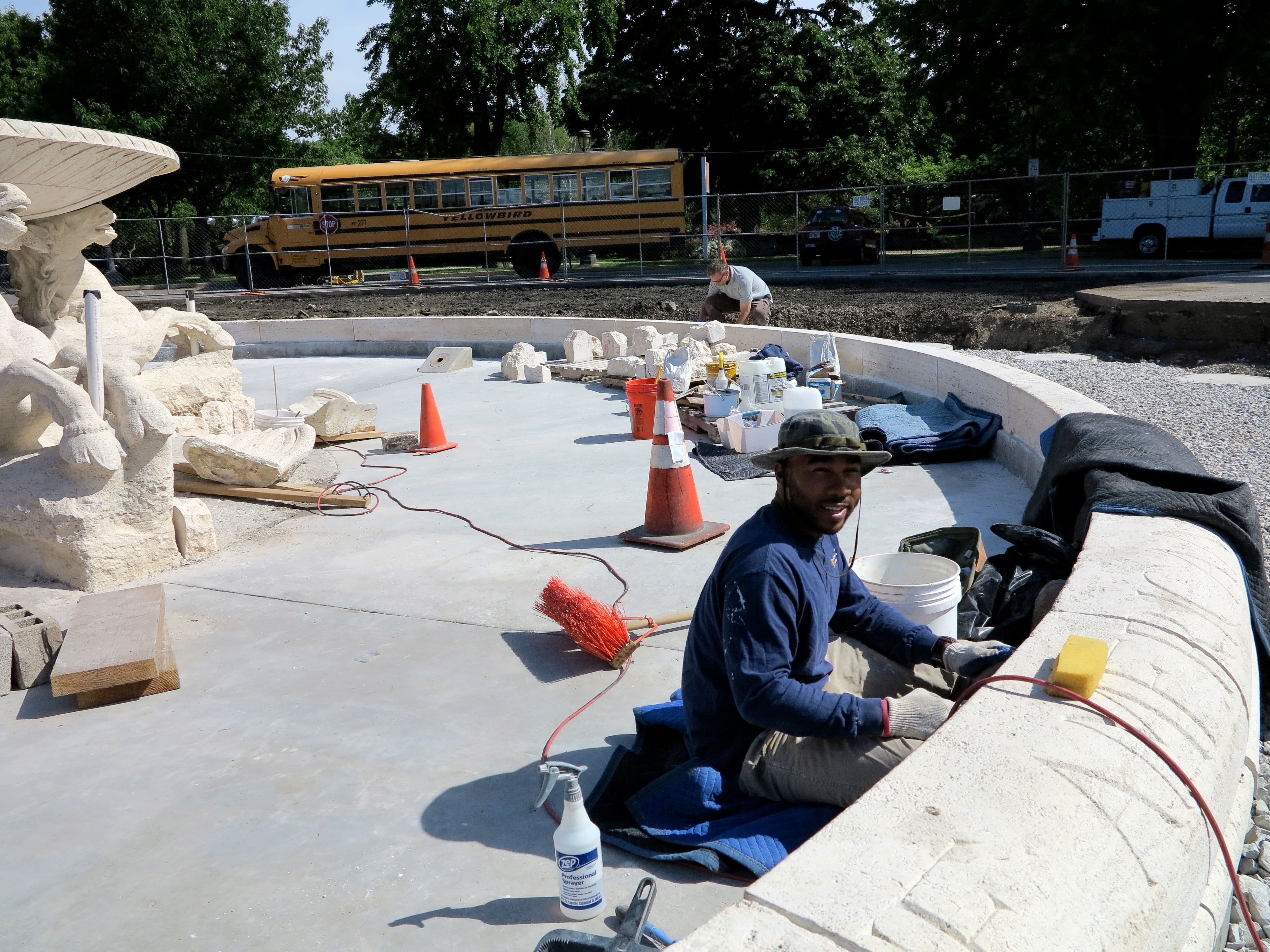 Conservation technician Darryl Branch adding mortar between the coping stone pieces surrounding the basin.