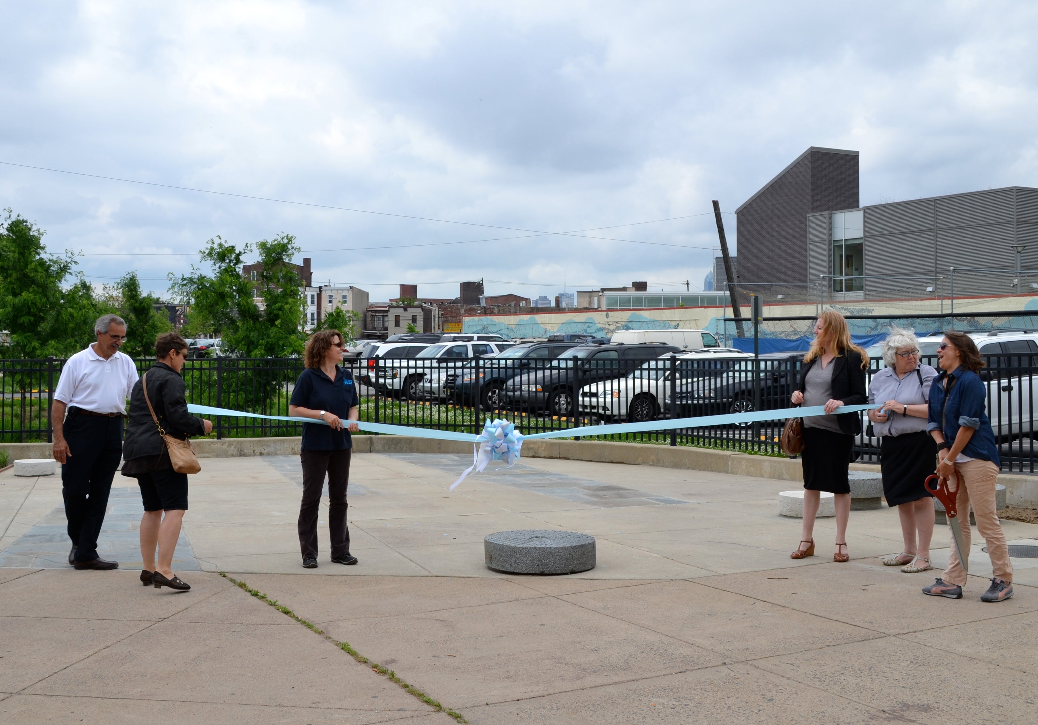 Project leaders got ready to cut the ribbon before the sprayground dedication