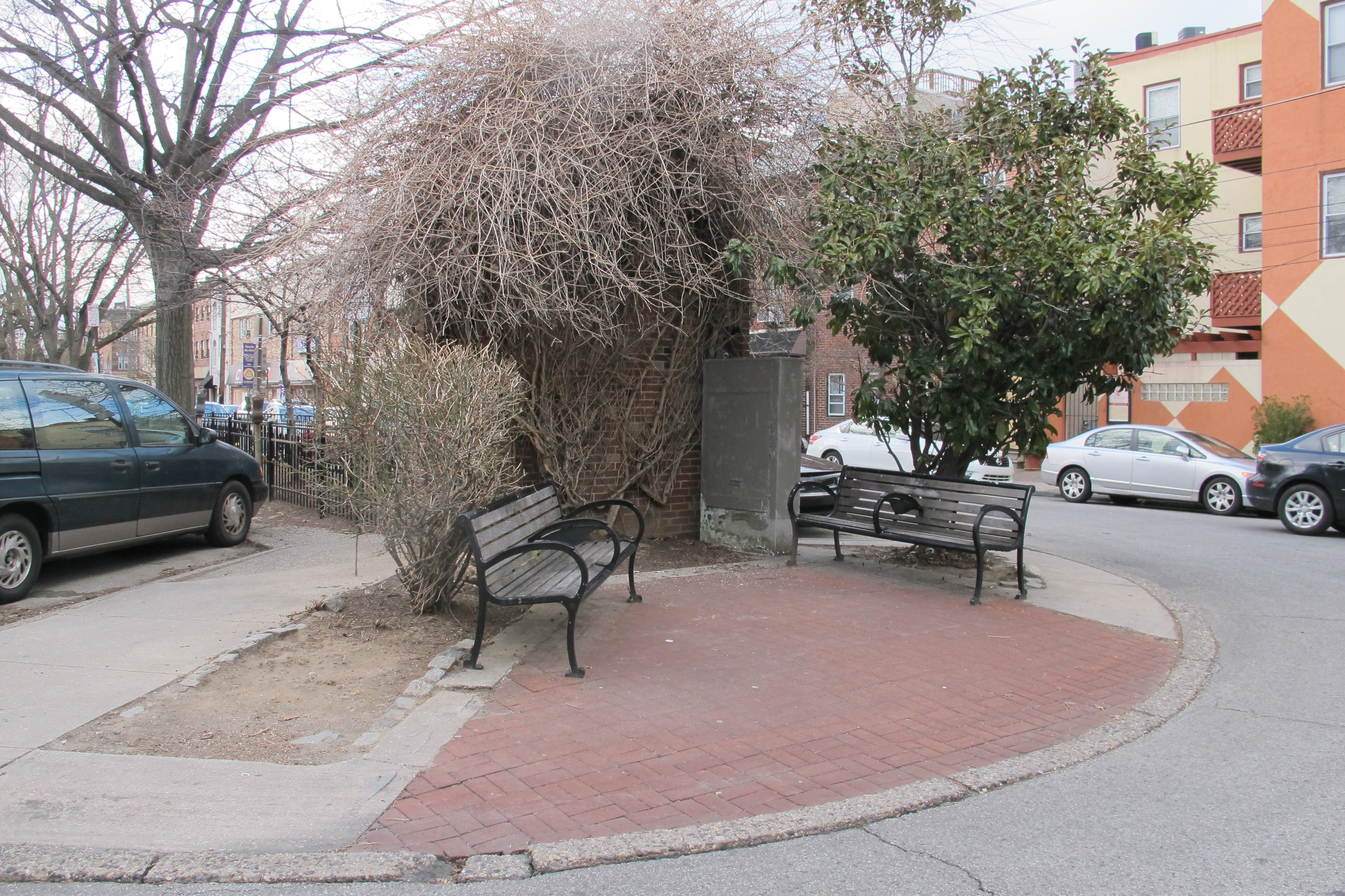 The tired, oddly shaped plaza at 3rd Street features an overgrown brick wall that once had a veterans memorial on it.
