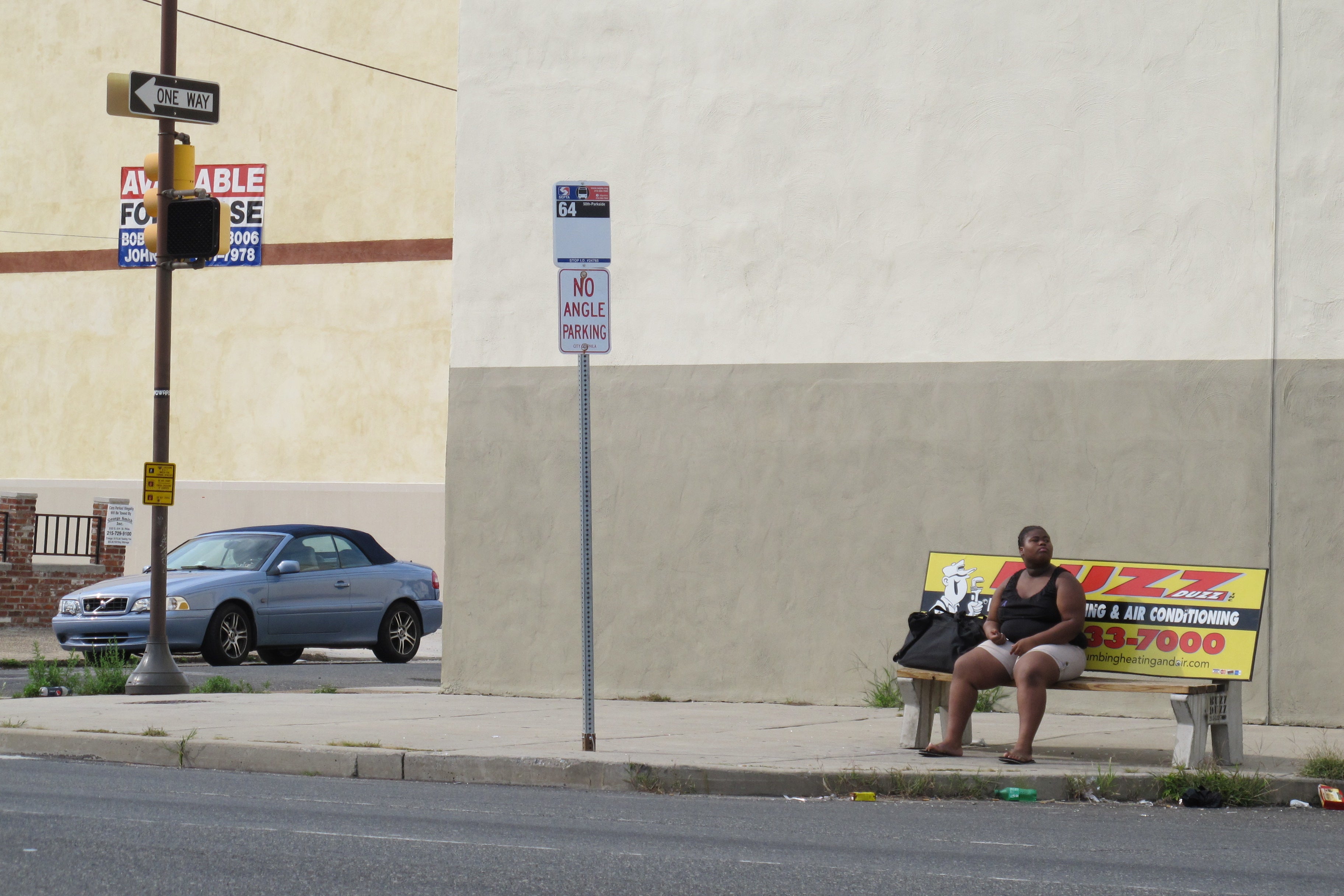 Waiting for the 64 on a Buzz Duzz bench on Washington Ave July 2012. (removed)