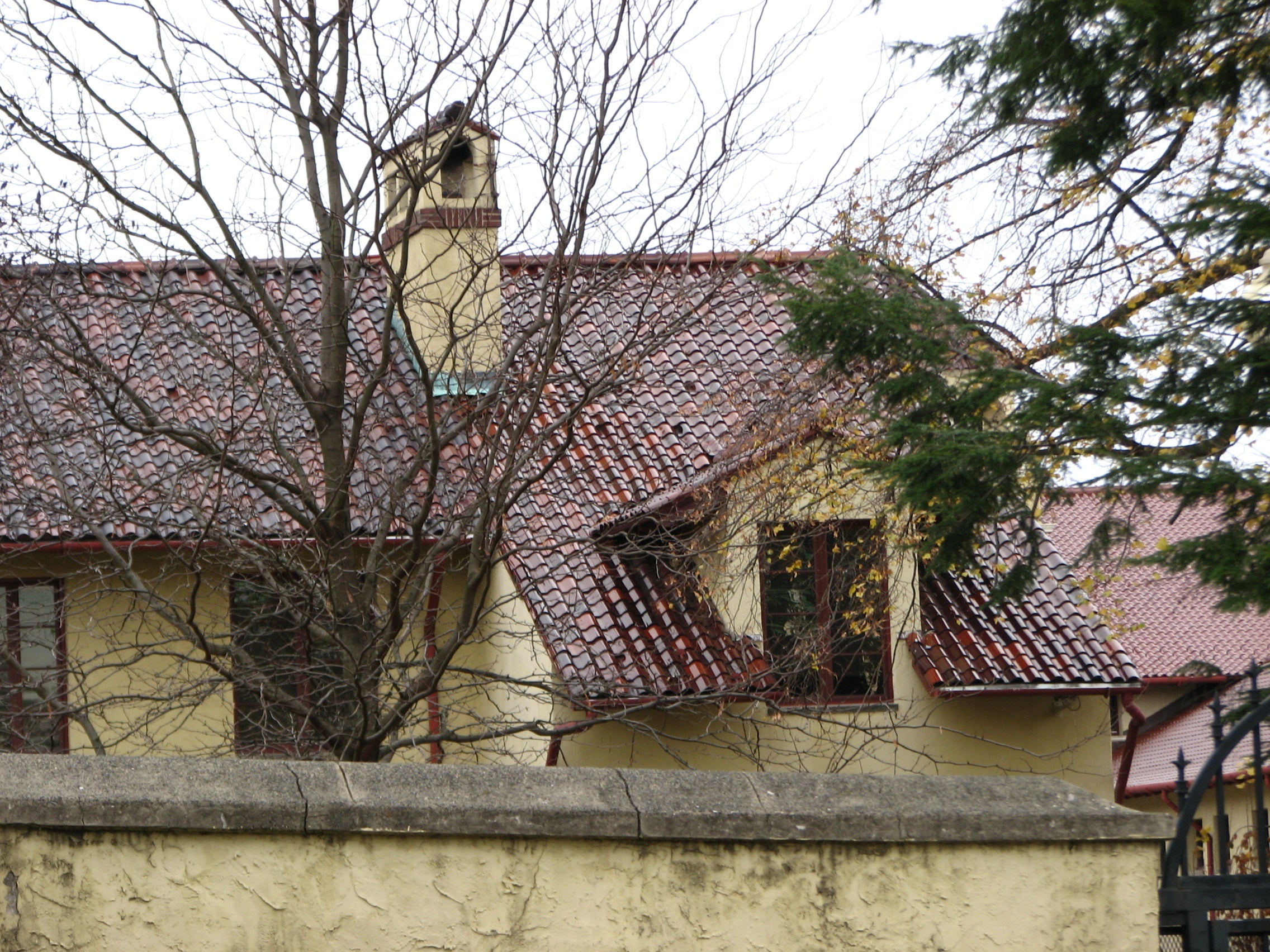 Red tile roofs peak over the yellow wall that surrounds the campus.