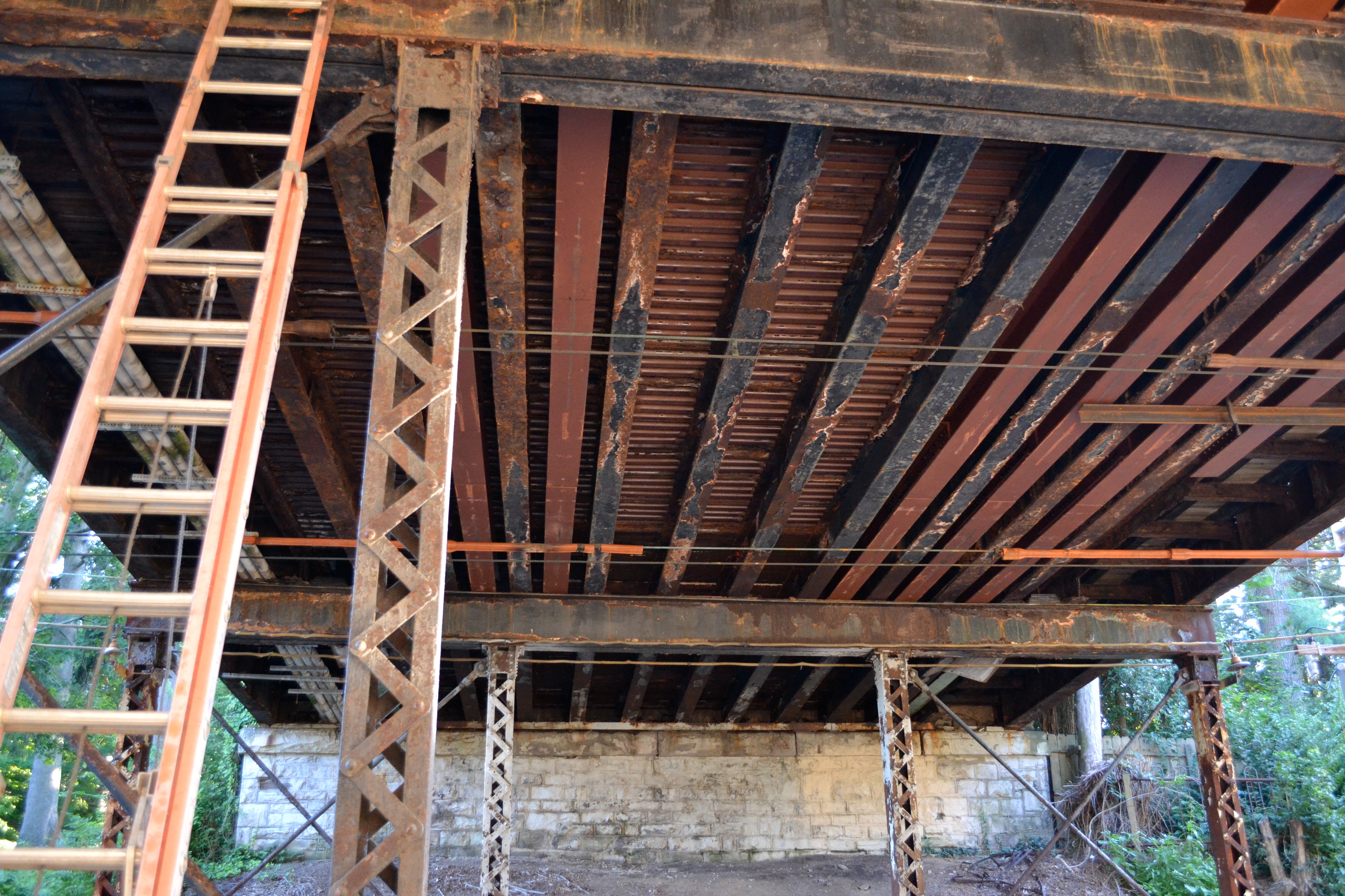 The new beams fit between and reinforce the old, corroded beams