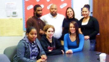 Inside the Excel Academy South in Northwood, Executive Director Milton Alexander stands with Stephanie Buca and a select group of the interviewed honor students.  Photo by Maria Konidaris.