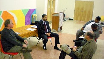 Paul Deery, a spokesman for Urban Eco Electric at left, and three Frankford residents listen to state Rep. Tony Payton's Chief of Staff Jorge Santana introduce their discussion on solar energy opp