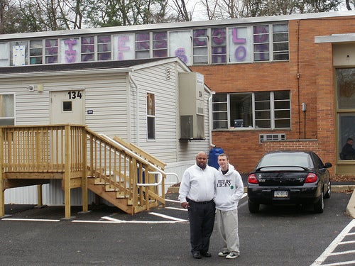 Outside the Excel Academy South in Nothwood, Northeast Philadelphia, Executive Director Milton Alexander stands with student Nick Rhoades.  Photo by Maria Konidaris.