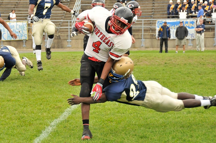 Washington's junior defensive back Martin Karton (23) puts a flying tackle on Northeast's #4. Washington's junior defensive back Martin Karton (23) puts a flying tackle on Northeast's #4.