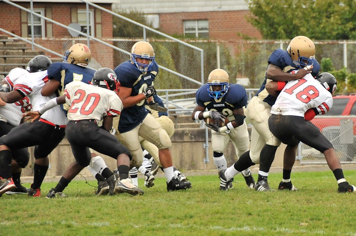 It's the big guys who open the lanes, but rarely do they get the praise they deserve. Here Eagles'  Abdel Kanan (64) blocks out on Northeast's #20 and Floyd Sharrif (73) blocks down on #18