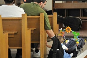 Joe Gonzalez attends to his 7-month-old son, Giovanni, during the service. Photo by Bill Achuff.