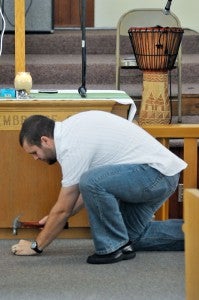 Pastor Rudd pretends to drive a stake into the floor, symbolizing the church's dedication to Jesus. Photo by Bill Achuff.