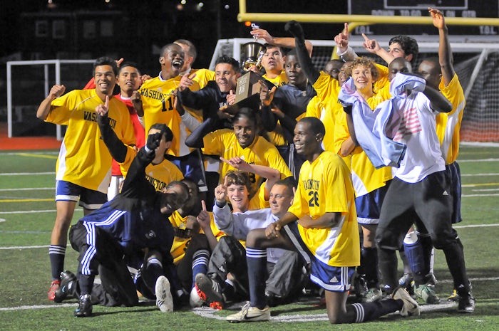 Seen holding their trophy and with their slightly damp first-year coach buried bottom center, the jubilant Washington High School 2009 Public League Soccer Champions pose for news and fan photos follo