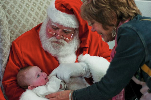 Santa, one of many honored guests at last Sunday's Parade of Talent, cuddles 3-month-old Feona Conti, who got a little help from grandmom Katie.