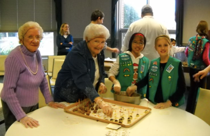 Wesley Enhanced Living at Evangelical Manor residents Alice Kanach (l) and Eleanor Schol (r), along with junior girl scouts from Troop #23463 and #24335 of Mt. Laurel, N.J., make homemade holiday cand