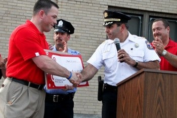 Captain Joseph Joseph F. Zaffino, Commanding Officer of the 7th District Police Department shakes hands with a representative of Target and accepts a check on behalf of the Captain of the 2nd Distric Captain Joseph Joseph F. Zaffino, Commanding Officer of the 7th District Police Department shakes hands with a representative of Target and accepts a check on behalf of the Captain of the 2nd Distric