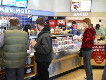 Customer wait in anticipation for long-awaited doughnuts.