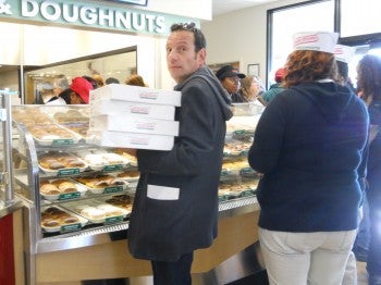 A customer buys four dozen original glazed doughnuts at Krispy Kreme's grand opening, Tuesday, Nov. 9.